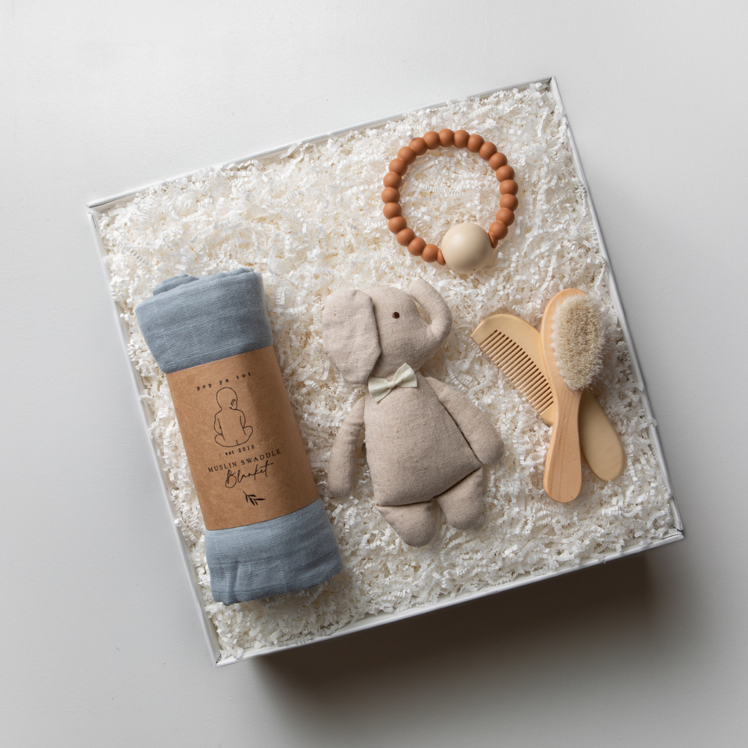 White gift box for baby showers, newborn, new baby. Muslin wrap, teether, soft toy, rattle, baby brush set.