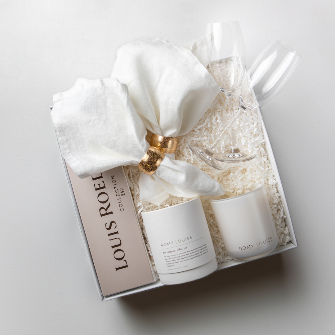 White gift box with champagne, napkins, napkin rings, candle and crystal flutes. Perfect for settlement gifts, corporate gifts, gifts for the home, mother&#39;s day gift, gift for mum