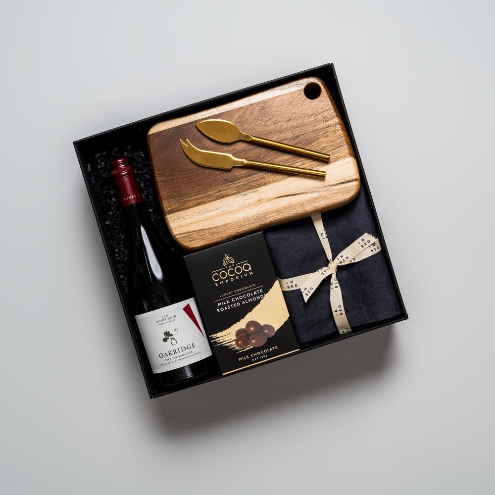 A LÂPACH thank-you gift box with gourmet items and serveware.