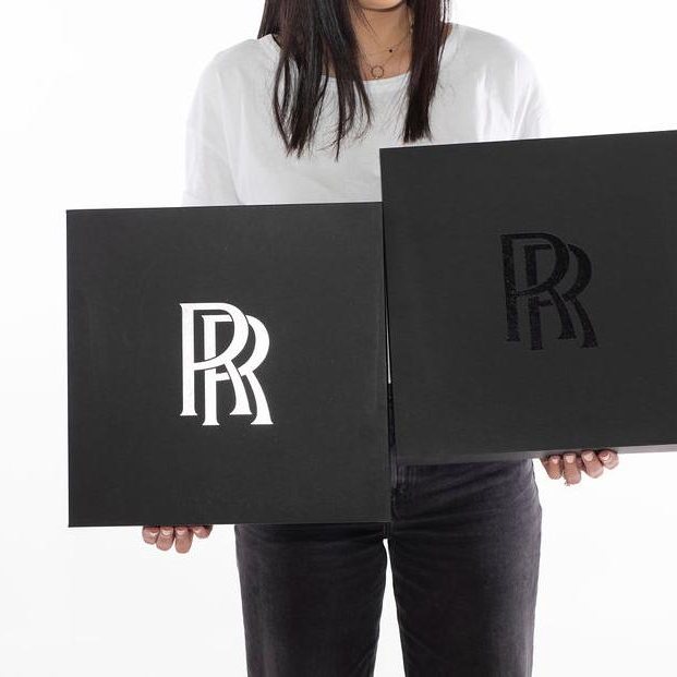 Two black rigid gift boxes with hot-foil stamped Rolls-Royce logos, produced by LÂPACH.