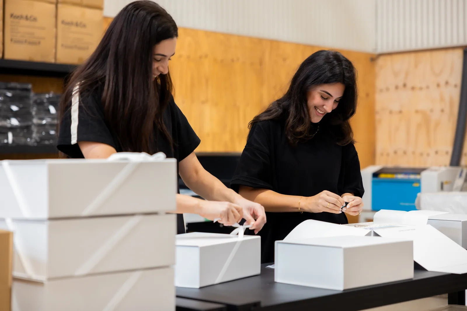 Two members of the LÂPACH team hand-packing gift boxes at the Brisbane studio.